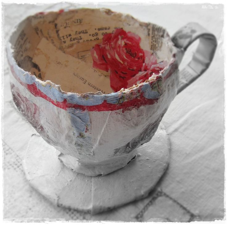 a paper mache bowl with red flowers in it