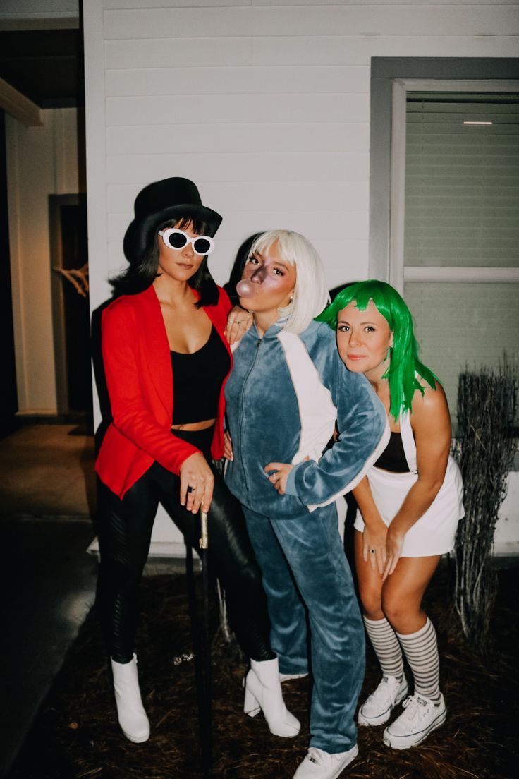 three women dressed in costumes posing for a photo