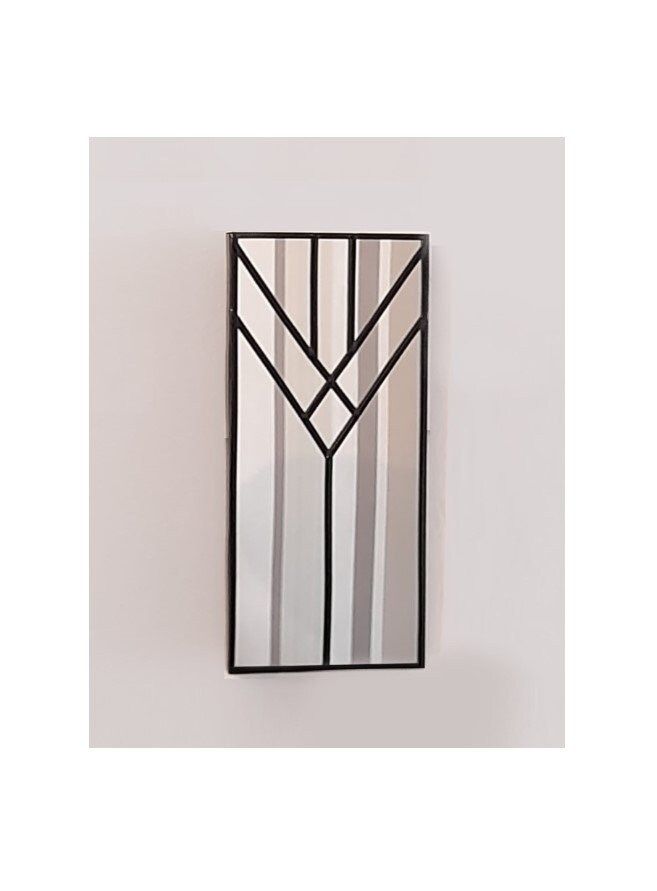 a black and white mirror hanging on the wall next to a light fixture with an arrow design