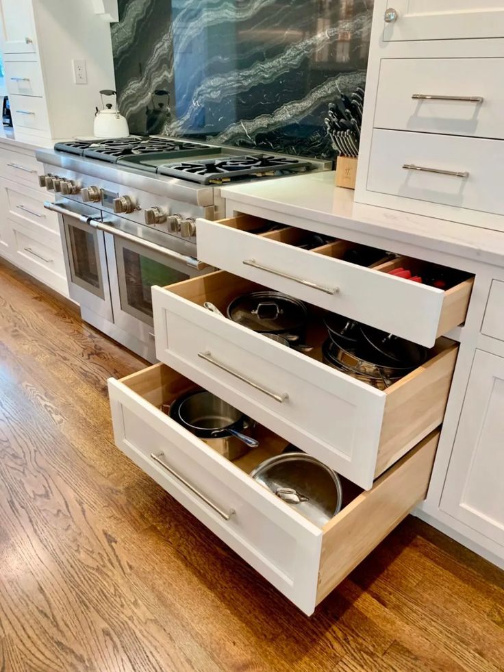 an open drawer in the middle of a kitchen