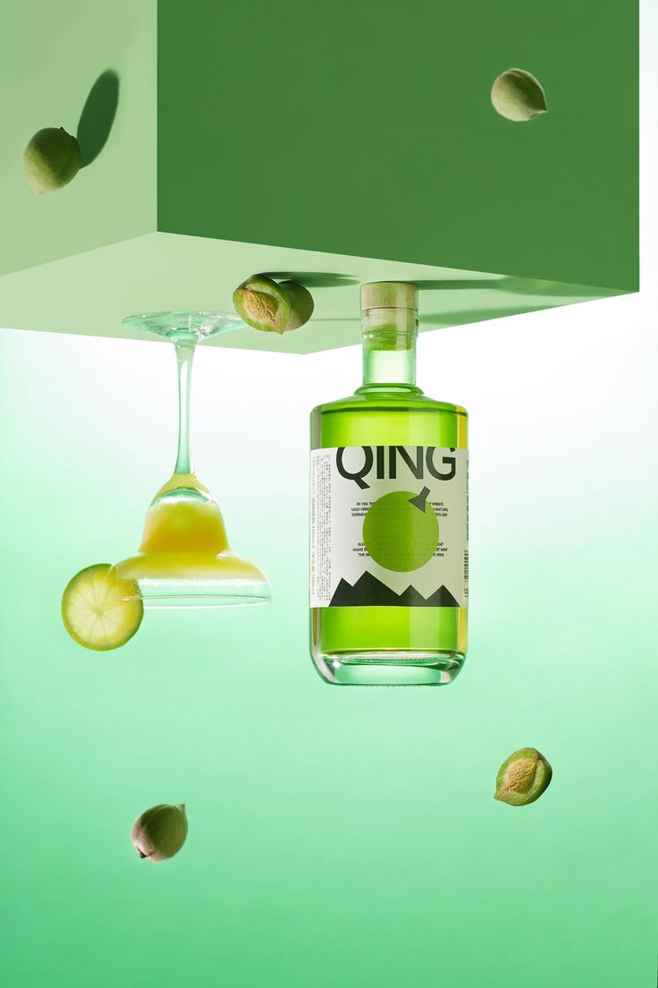 a bottle of gin is suspended from the ceiling with slices of cucumbers around it