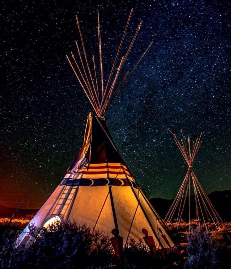 a teepee is lit up with stars in the sky