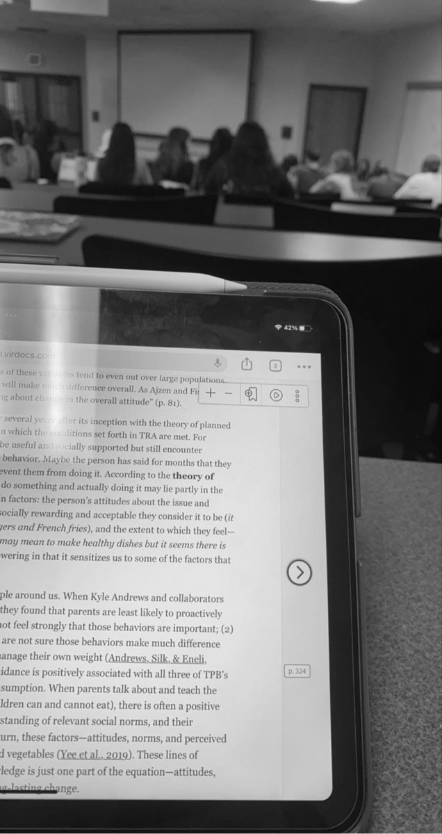 an open tablet computer sitting on top of a table in front of a group of people