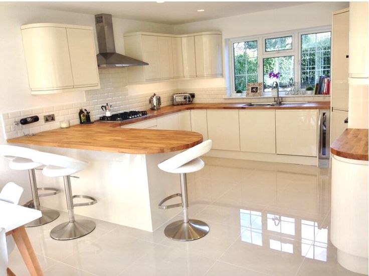 a kitchen with two stools and a counter in the middle, next to a sink