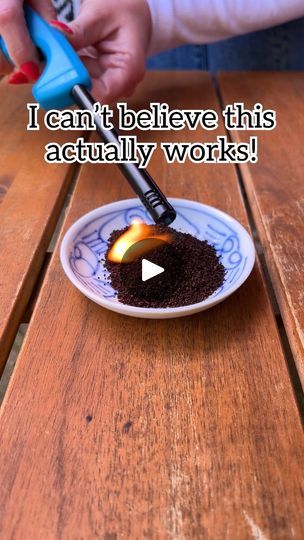 a person is using a small device to burn something in a bowl on a wooden table