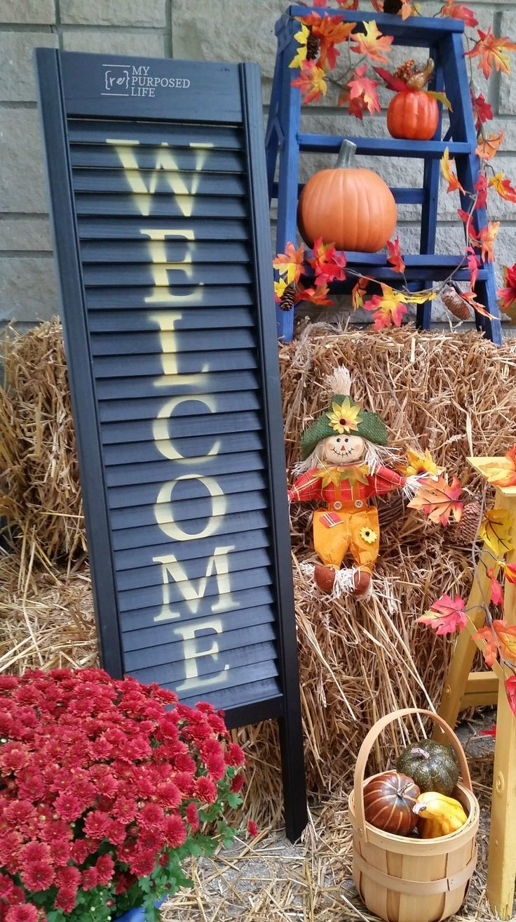 an outdoor display with pumpkins, hay and decorations