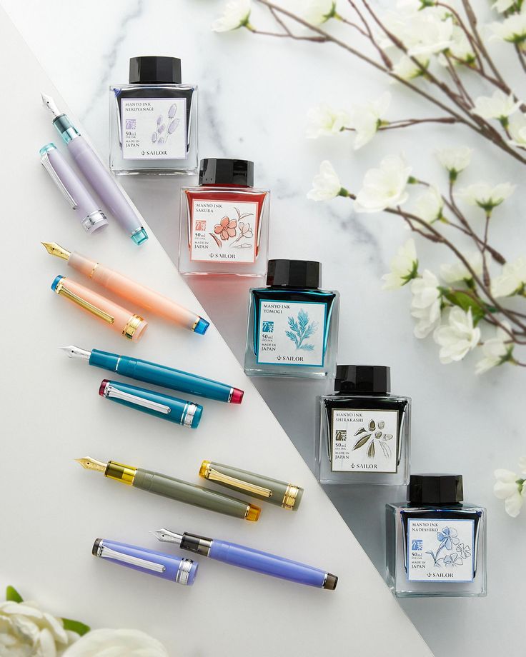 five different types of fountain pens lined up next to each other on a marble surface