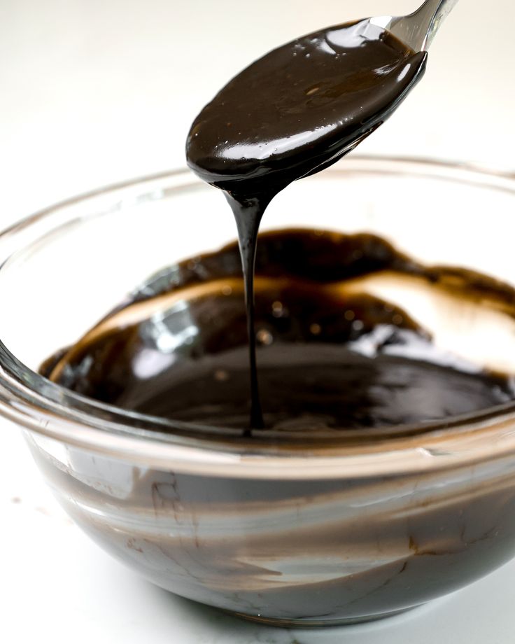 a spoon full of melted chocolate in a bowl