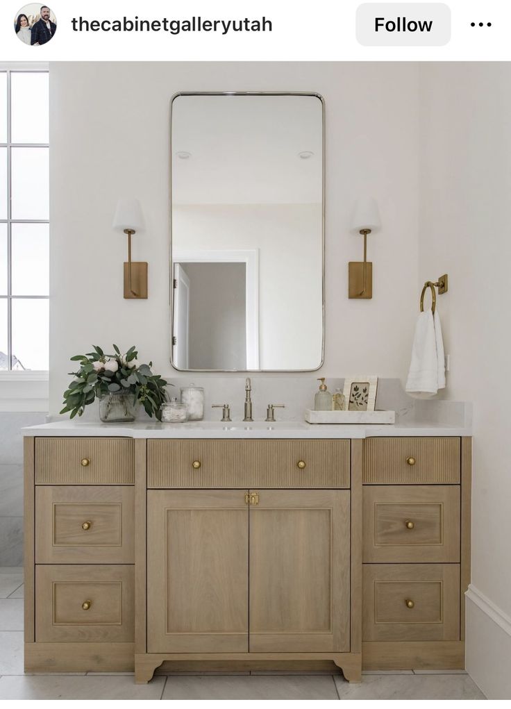 a bathroom vanity with two sinks and a large mirror