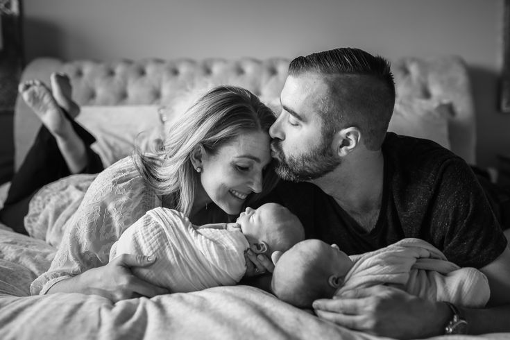 a man and woman laying in bed with their baby