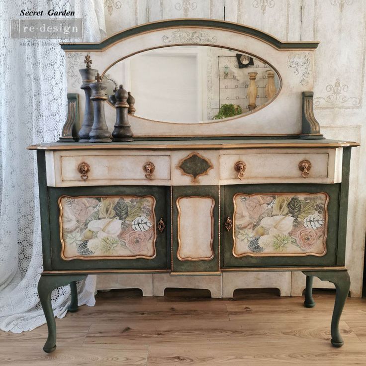 an old dresser has been painted with flowers and leaves on the side, along with a mirror