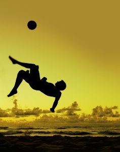 a person jumping into the air to catch a frisbee in front of an orange and yellow sky