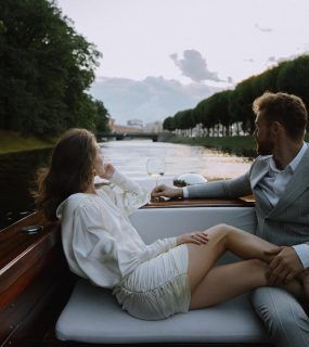 a man and woman sitting on the back of a boat