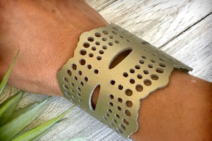 a close up of a person's arm wearing a bracelet with holes on it