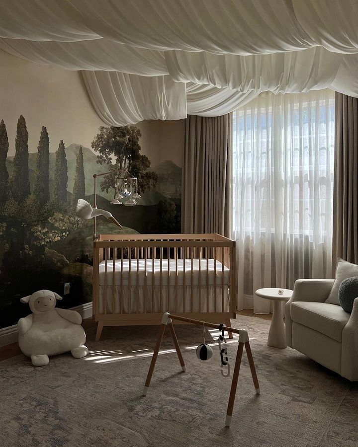 a baby's room with a crib, rocking chair and painting on the wall