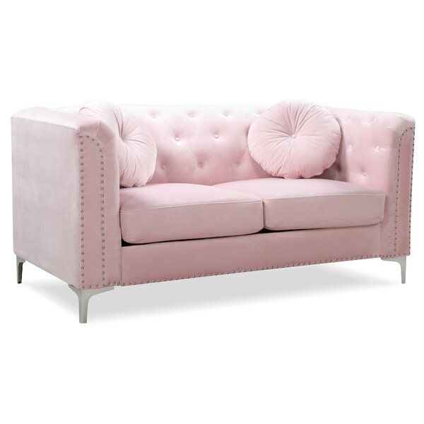 a pink couch with two pillows on it