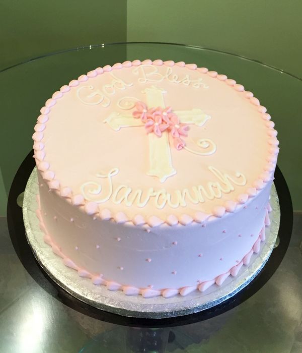 a pink and white cake sitting on top of a glass table