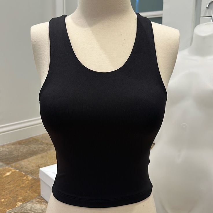 Pullover Style Form Fitting 84% Polyamide, 16% Lycra Black Tank Crop Top With Built-in Bra, Black High Stretch Crew Neck Tank Top, Black Scoop Neck Crop Top For Workout, Black Scoop Neck Crop Top With Built-in Bra, Everyday Black Seamless Crop Top, Chic Scoop Neck Workout Tops, Black Tank Crop Top With Seamless Construction, Black Seamless Tank Crop Top, Black Cropped Tank Top For Everyday