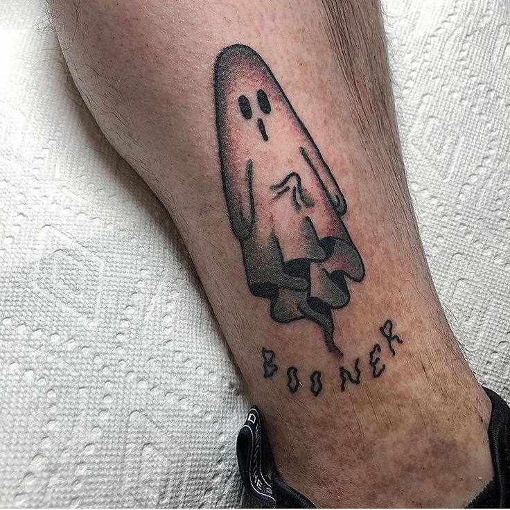 a tattoo on the leg of a man with a ghost in it's head