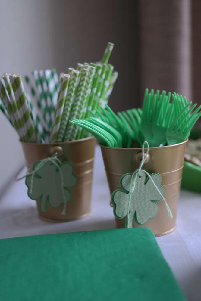 green and white st patrick's day party supplies in small pots on a table