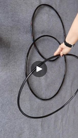 a person is holding a black jump rope with an arrow in the middle and one hand on top of it