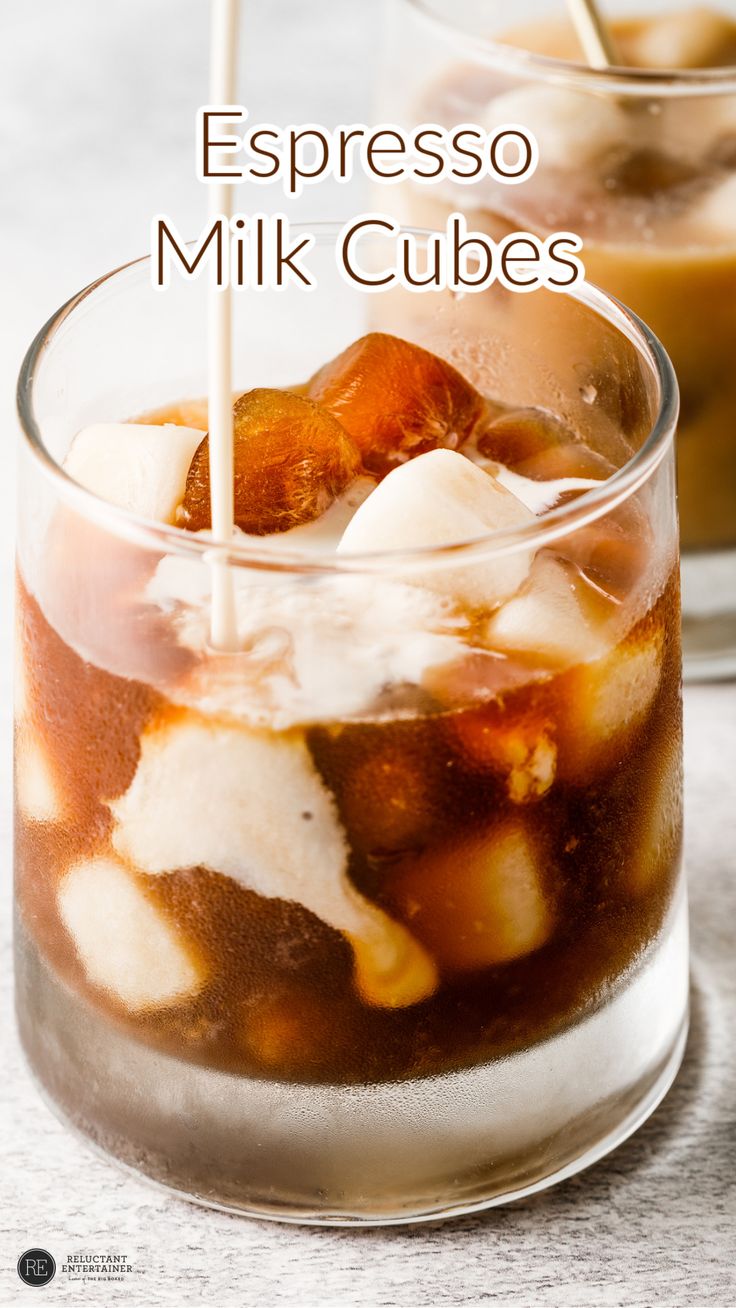 two glasses filled with ice and milk on top of a table