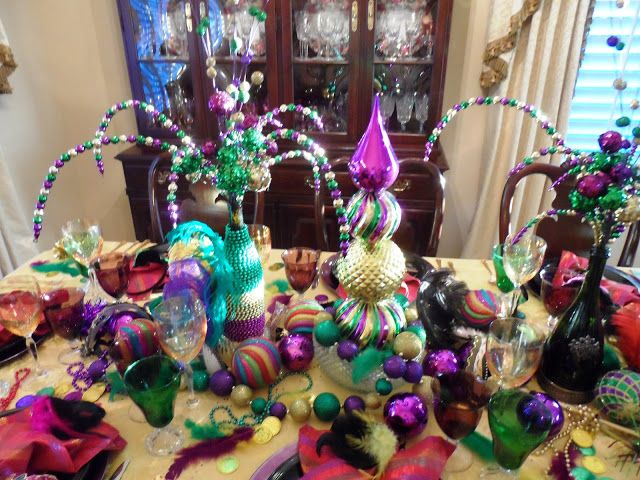 the table is covered with many different colored items and decorations, including glass vases