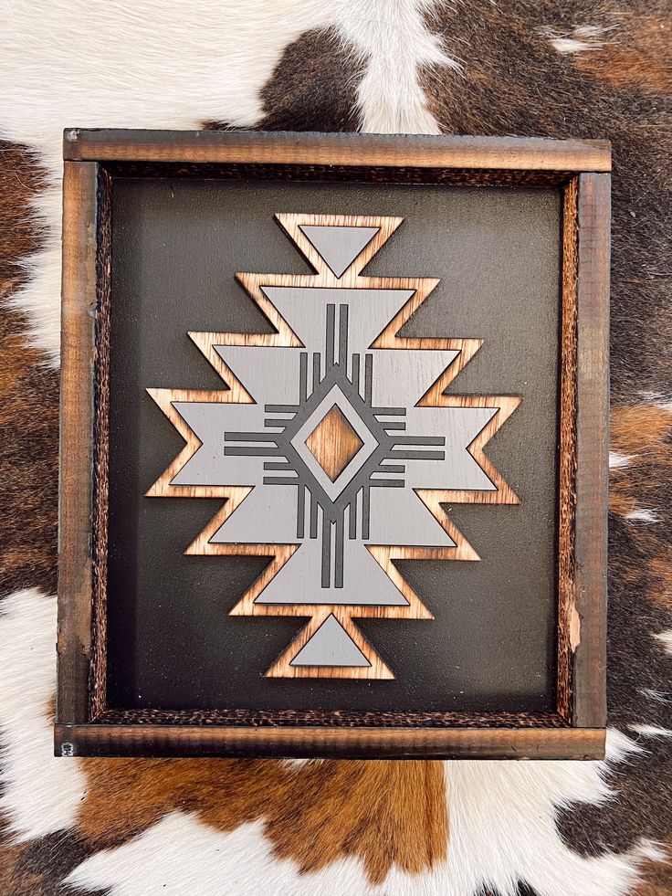 a wooden frame with an intricate design in it on a cowhide pattern wallpaper