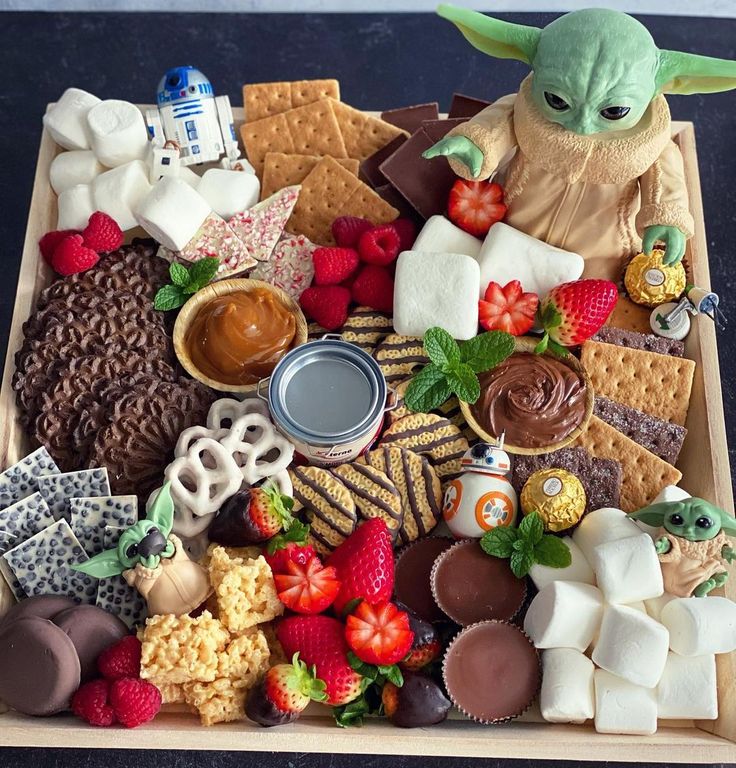 a star wars snack tray with yoda, crackers, strawberries and other snacks