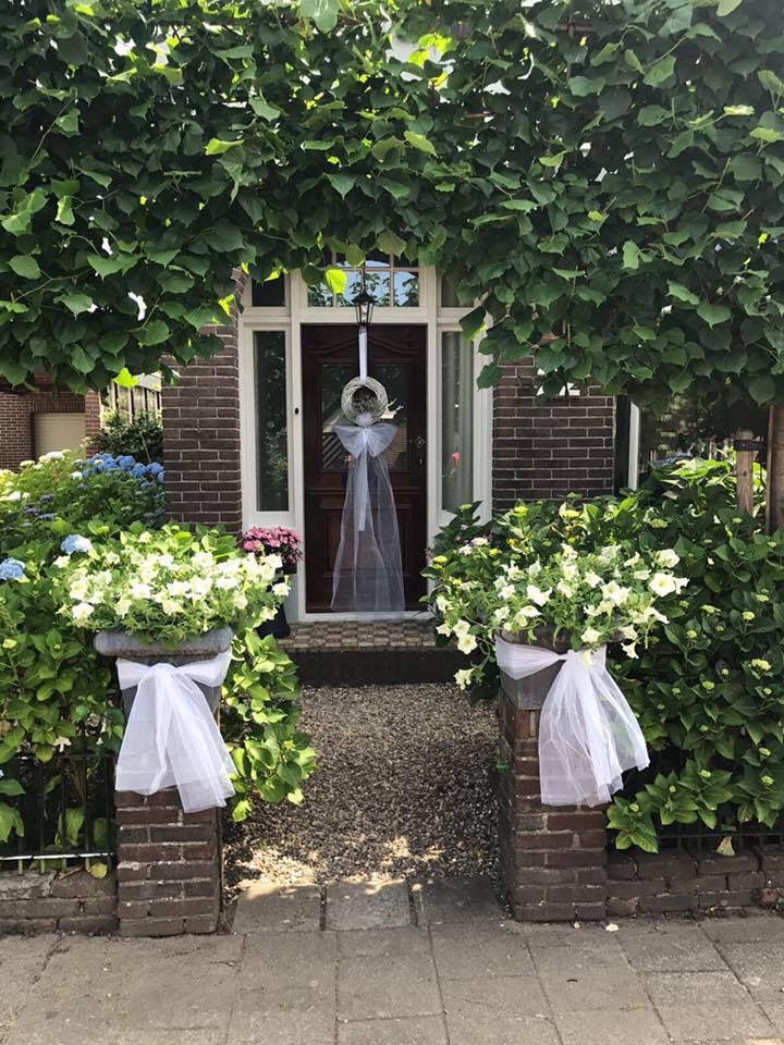 an entrance to a house with flowers and greenery