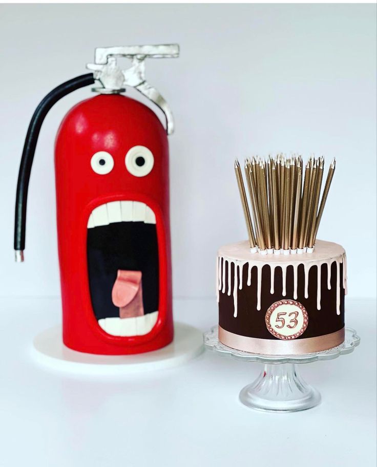 a birthday cake with an angry face on it next to a fire extinguisher