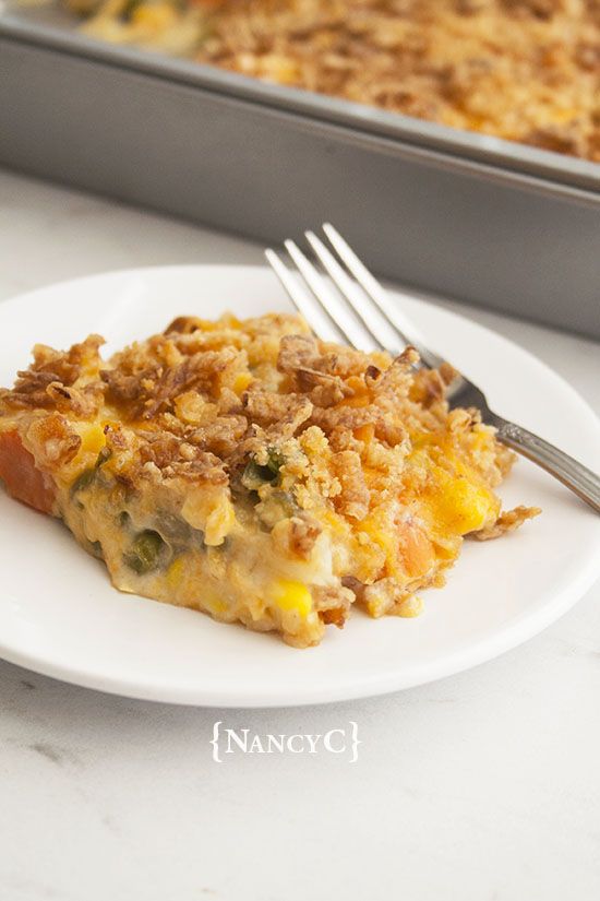 a piece of quiche on a plate with a fork next to the casserole