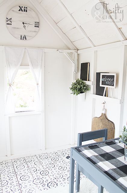 a room with a table, chair and clock on the wall