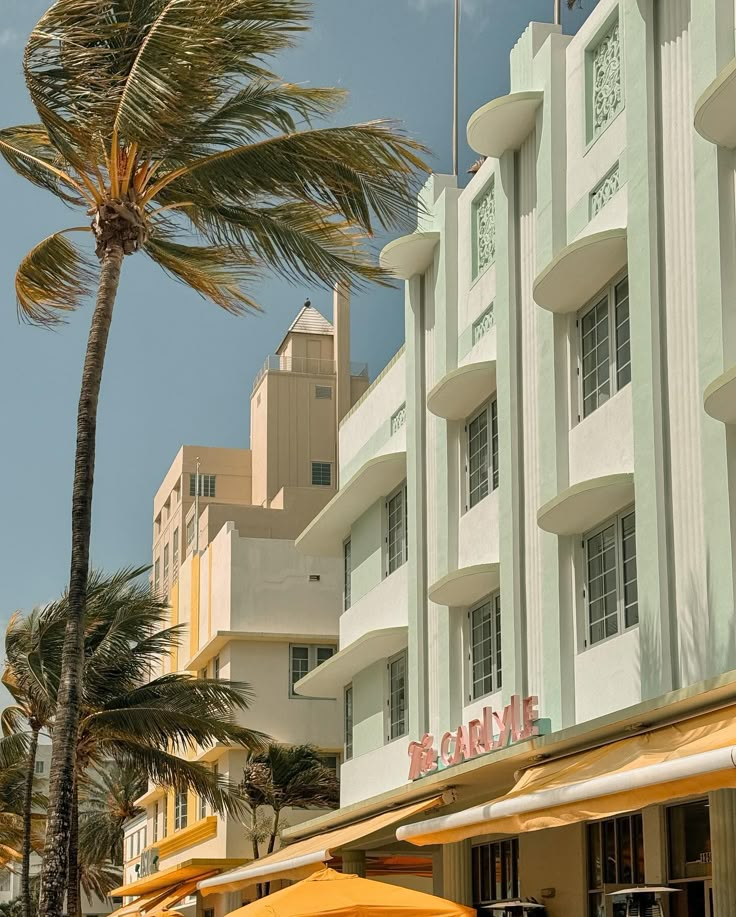 a hotel with yellow umbrellas and palm trees