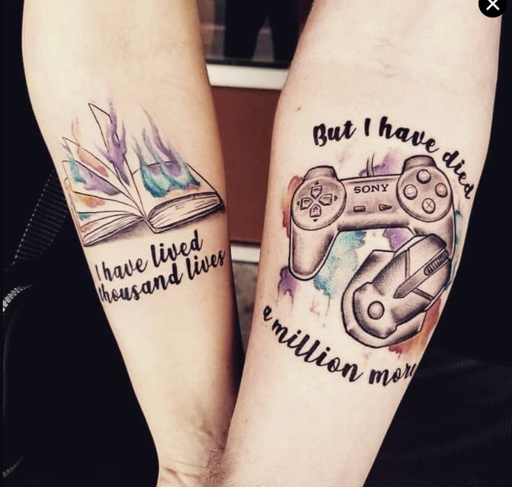 two people with matching tattoos on their arms holding game controllers and books, both have words written in them