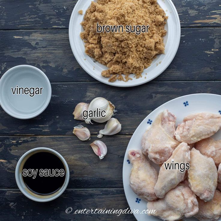 ingredients to make chicken wings on a wooden table with garlic, ginger and brown sugar