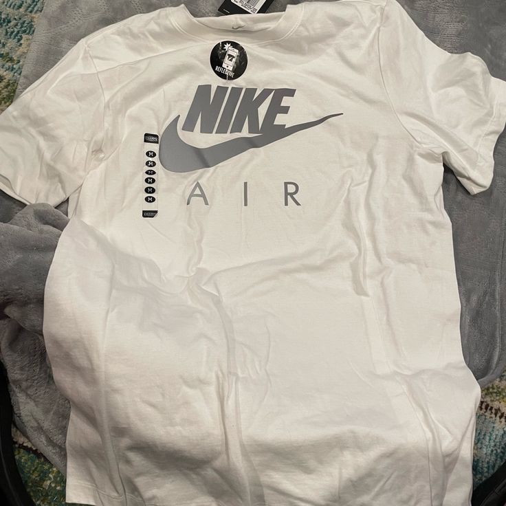 Nike Mens White Reflective Tee Nike Cotton Top, Nike White Cotton Shirt, Nike Cotton Tops With Branding, Urban White Tops With Logo Print, Urban White Crew Neck Top, Nike Urban Style Graphic Print Top, Nike Urban Top With Graphic Print, Nike Urban Short Sleeve Tops, Nike Urban Sports Tops