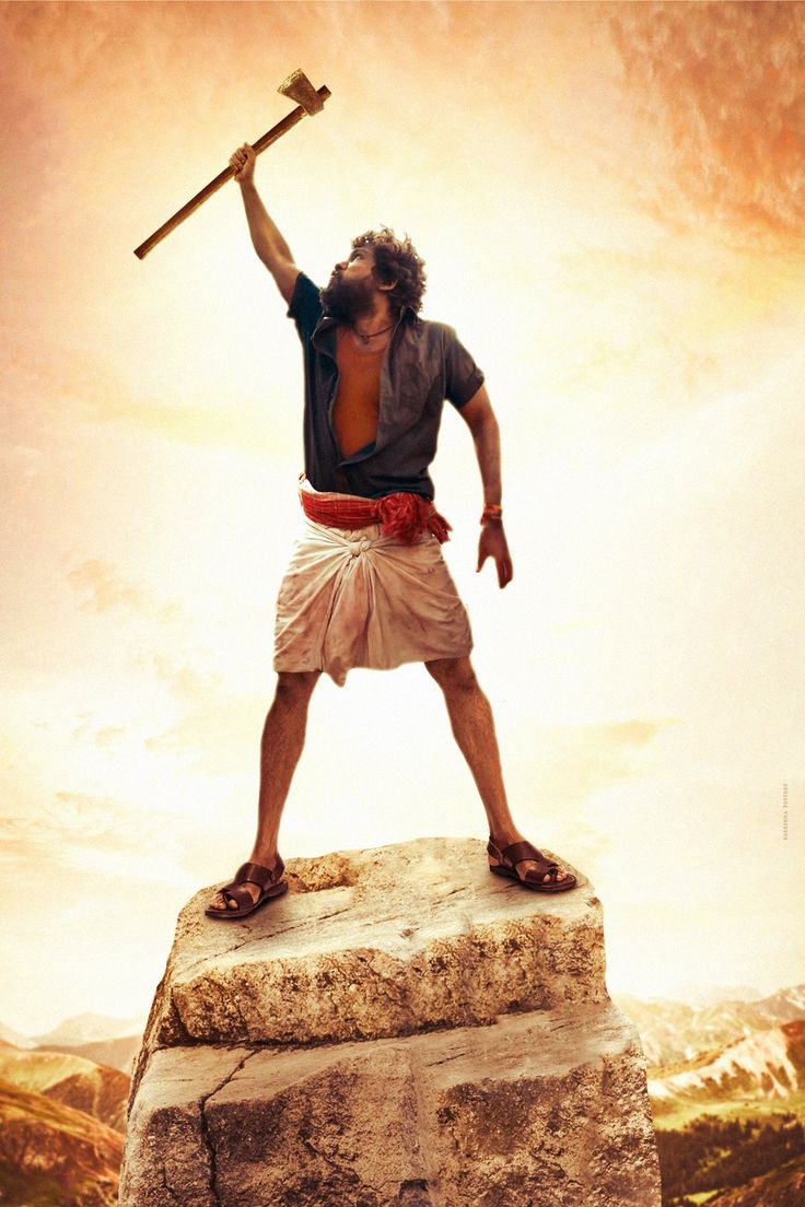 a man standing on top of a rock with an ax in his hand and holding a hammer