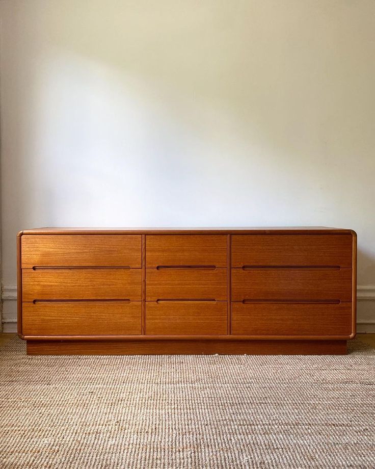 an empty room with a large wooden dresser