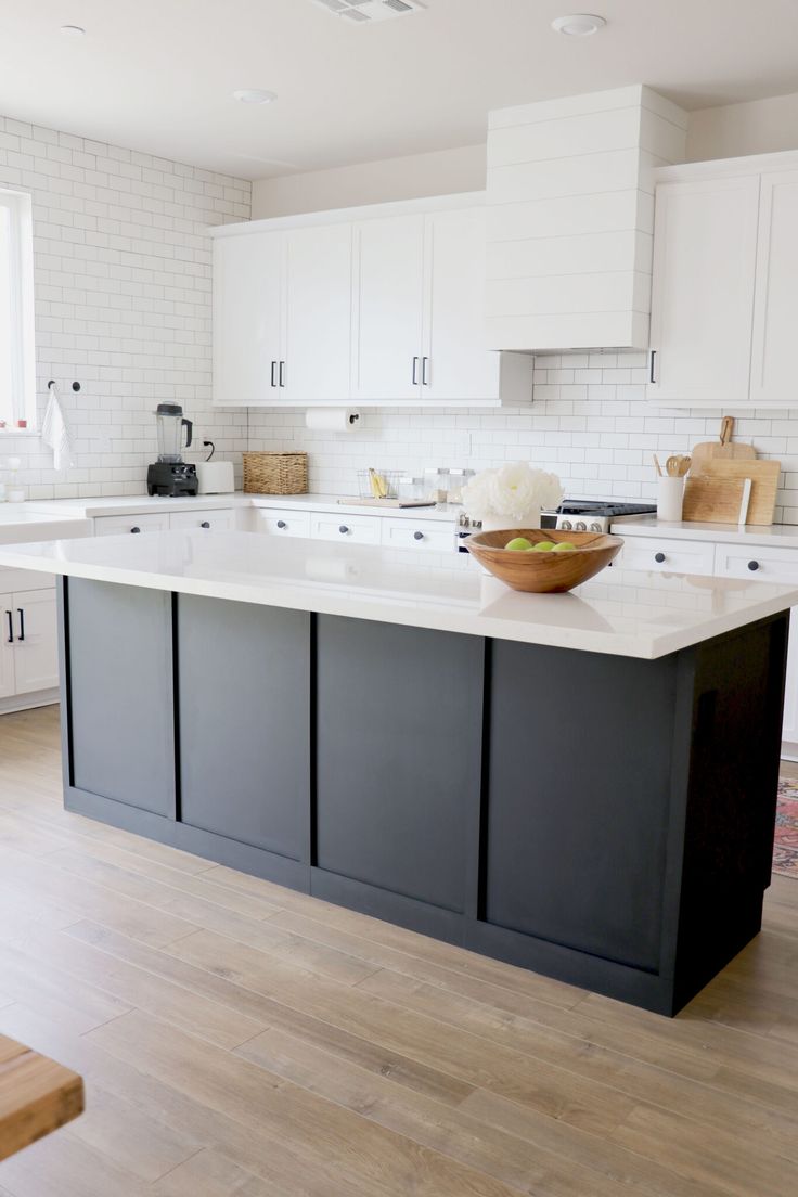 a large white kitchen with an island in the middle