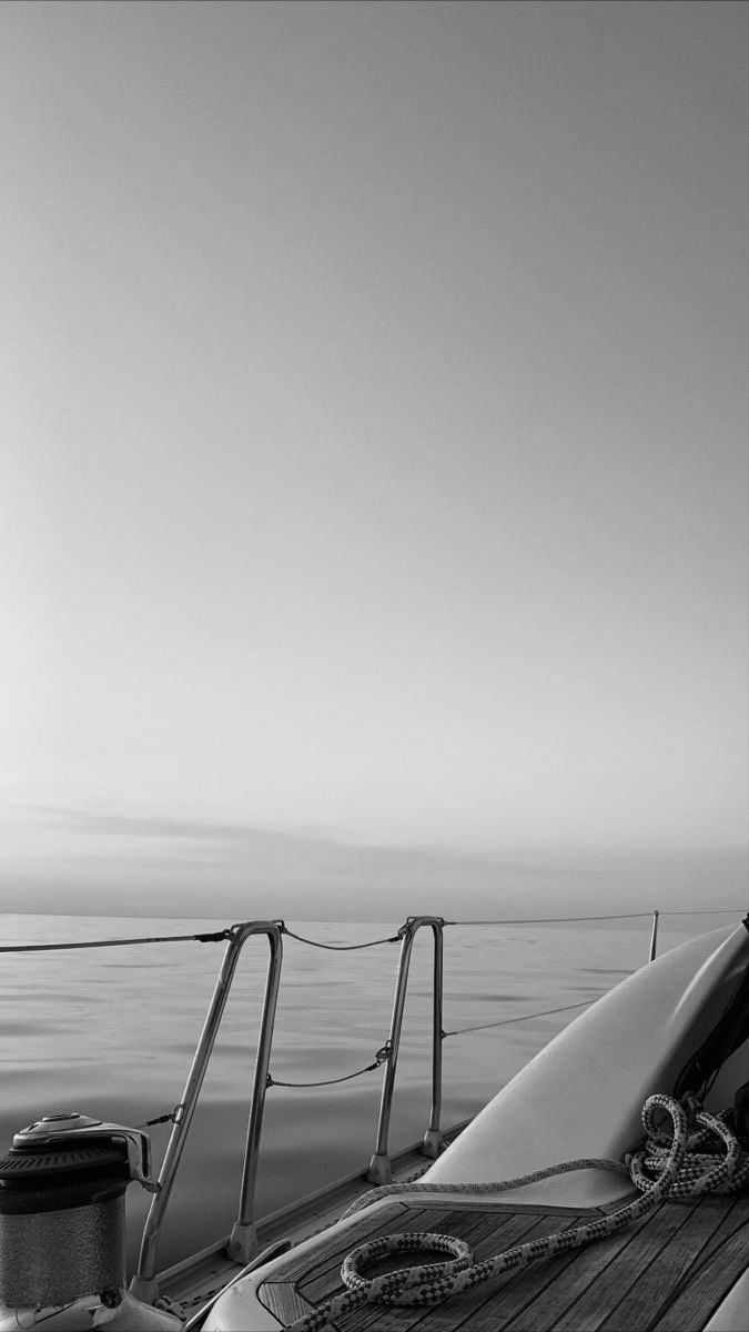 black and white photograph of the back end of a boat with water in the background