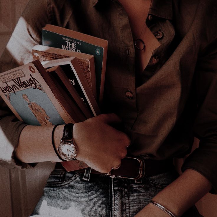 a woman holding several books in her hands