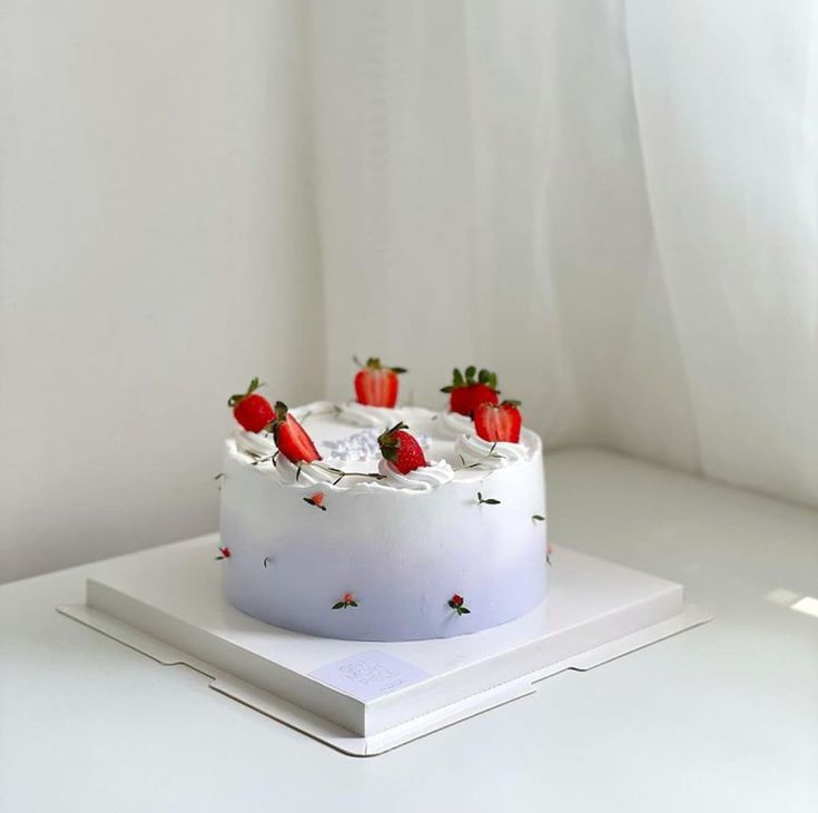 a white cake topped with strawberries on top of a table