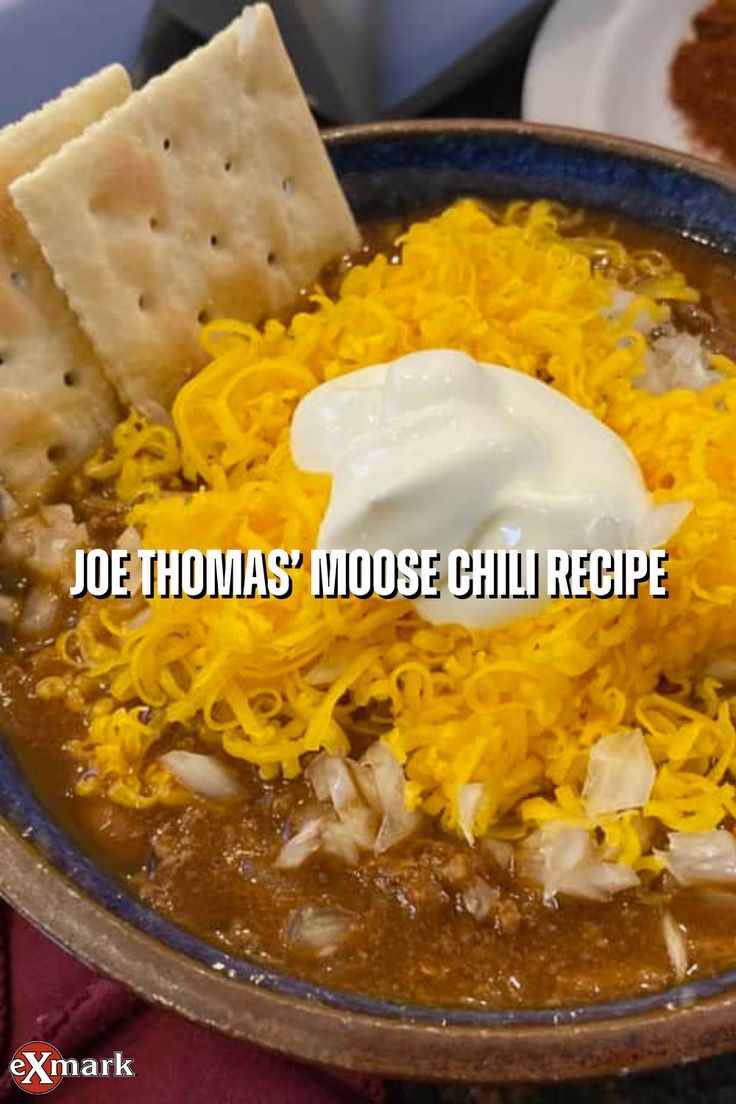 a bowl of soup with tortilla chips and sour cream on the side that says joe thomas'moose chili recipe