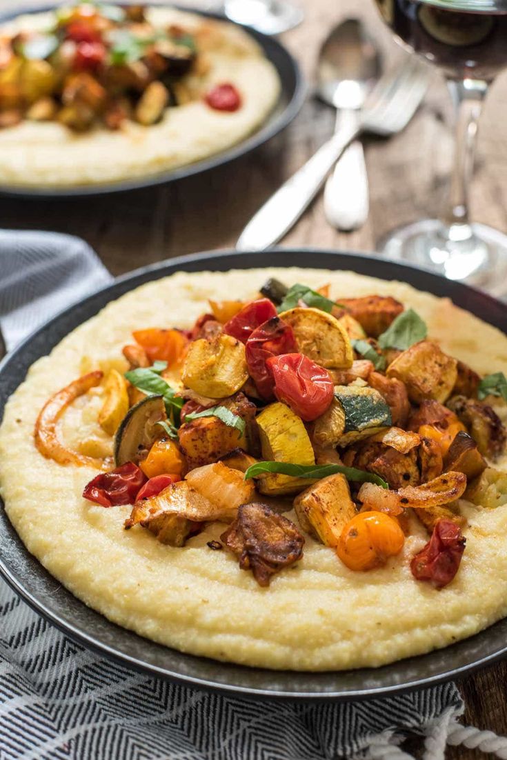 two pizzas sitting on top of a pan covered in cheese and veggies