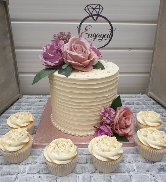 there is a wedding cake and cupcakes on the table