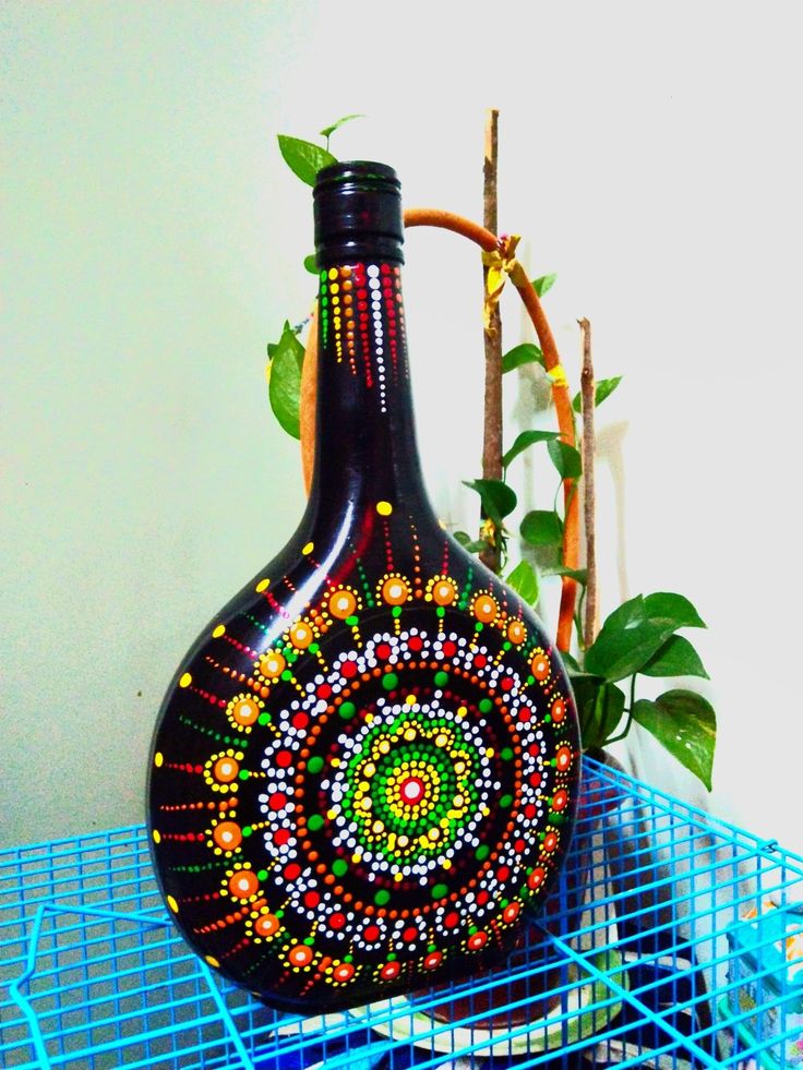 a decorative vase sitting on top of a blue wire rack next to a plant in a pot