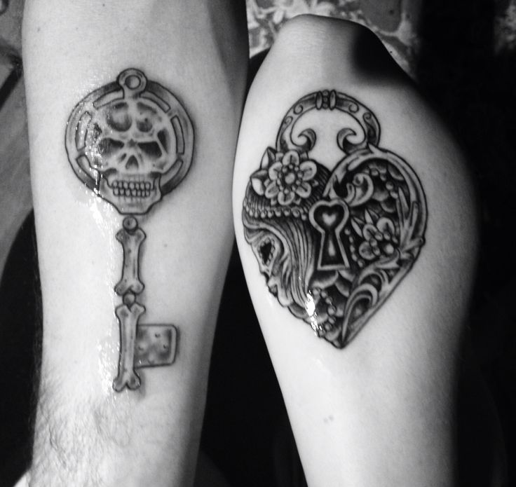 two people with tattoos on their legs and one is holding a key to the heart