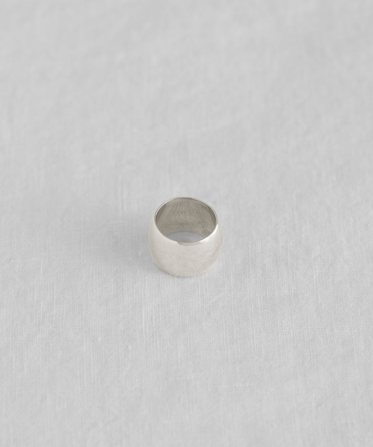 a silver ring sitting on top of a white surface