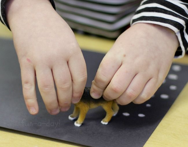 a child playing with a toy horse on top of a black mat and yellow table